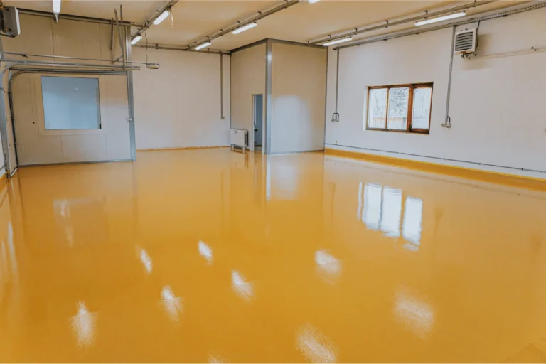 Bright yellow epoxy floor coating in an industrial room.