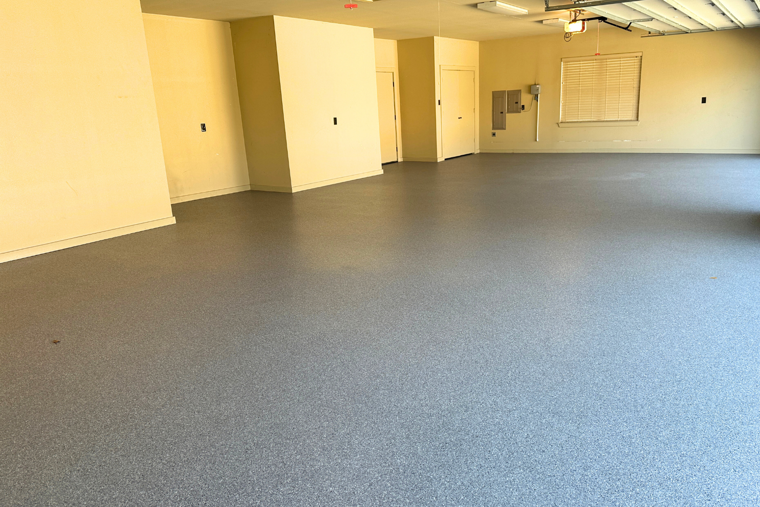 Smooth, finished polyaspartic garage floor coating with a custom blue color.