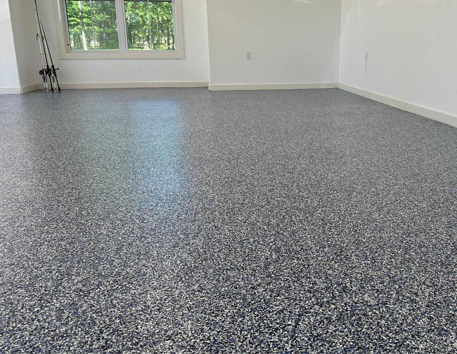Epoxy flake floor with a deep blue and gray blend in a sunlit room