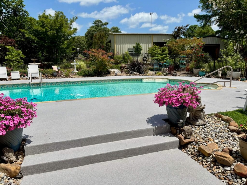 Pool deck steps and surround coated with light-gray quartz-broadcast outdoor system