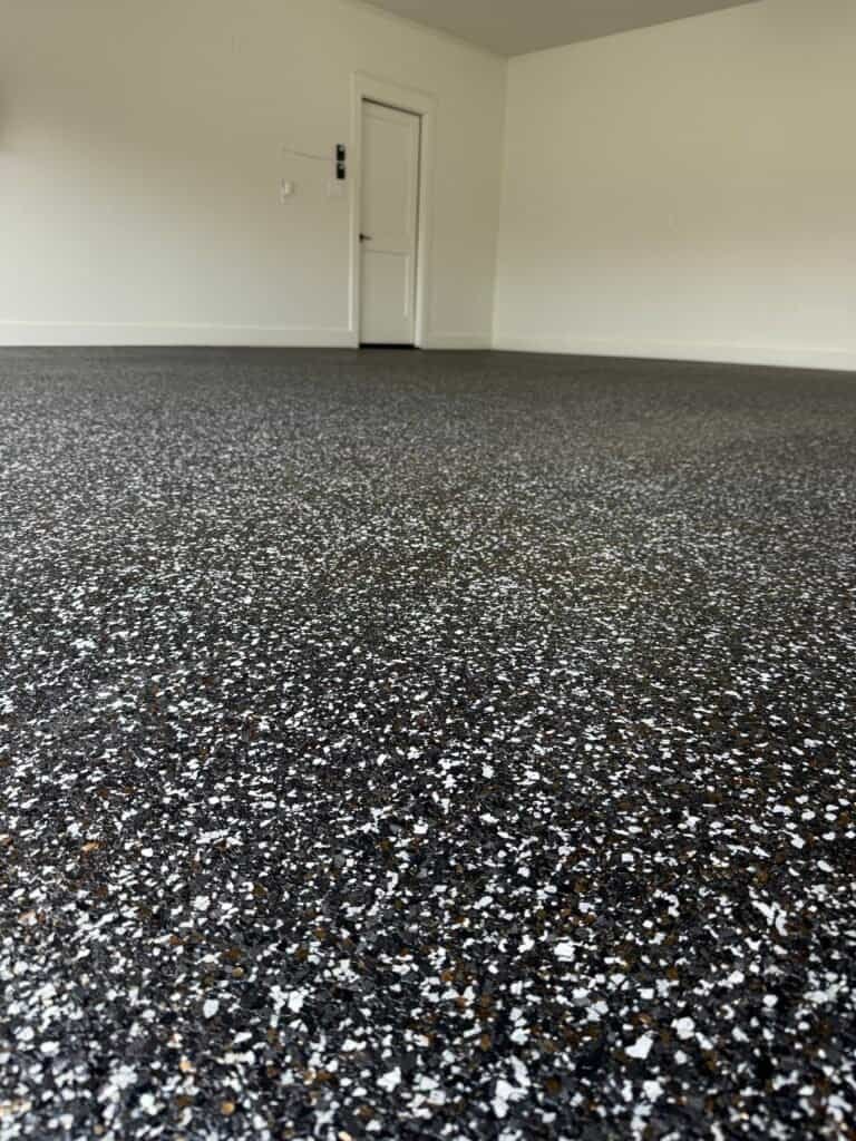 Epoxy resin flooring with black and white quartz in a modern interior space.