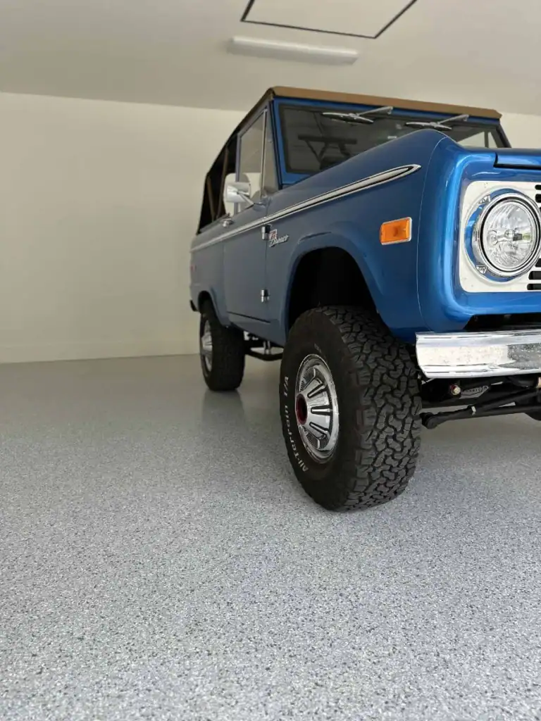 Bright blue classic off-road vehicle with epoxy resin-coated garage floor.