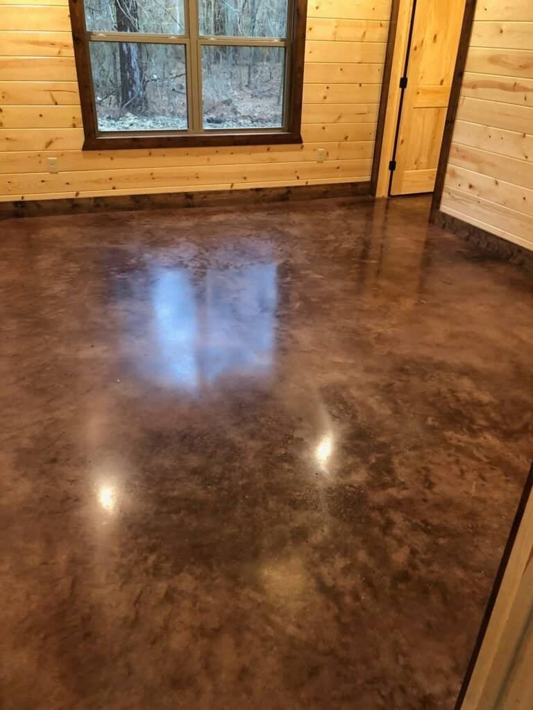 Polished epoxy floor in wooden cabin with window view.