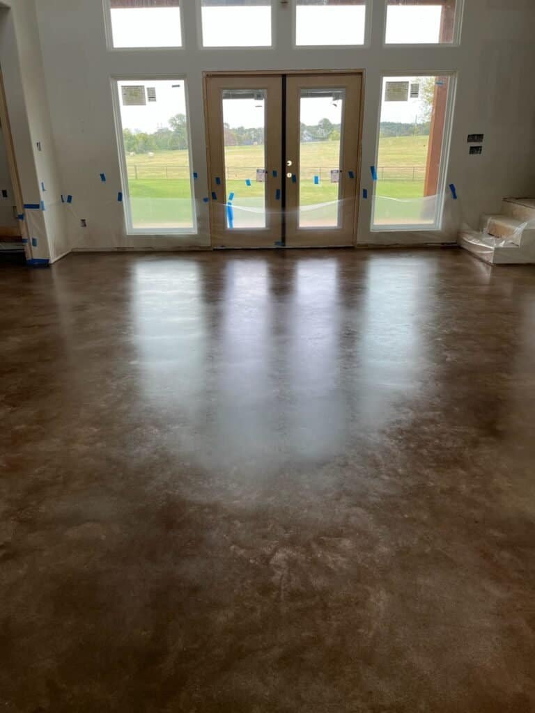 Polished epoxy-coated concrete floor in a bright room with large windows.