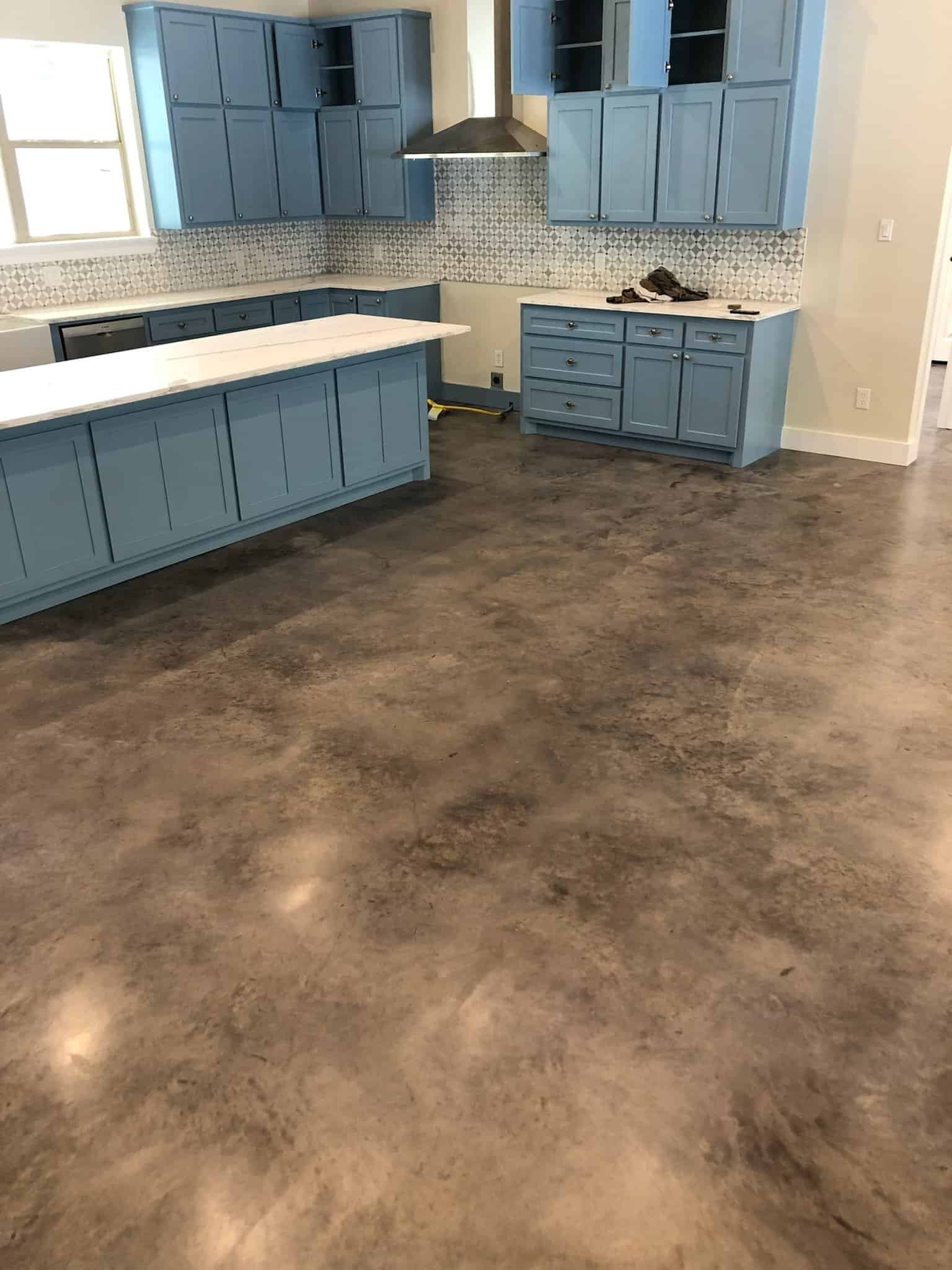 Durable epoxy coating on kitchen floor with blue cabinets and modern design.