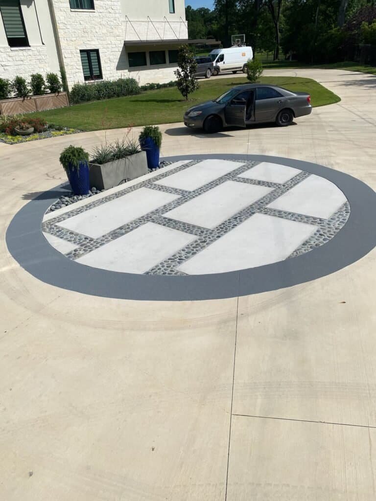 Custom black quartz driveway circle with decorative pattern at a Lake Tyler home.