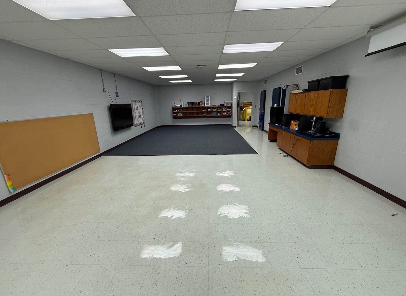 Clean epoxy coated floor in a spacious commercial room with ceiling lights.
