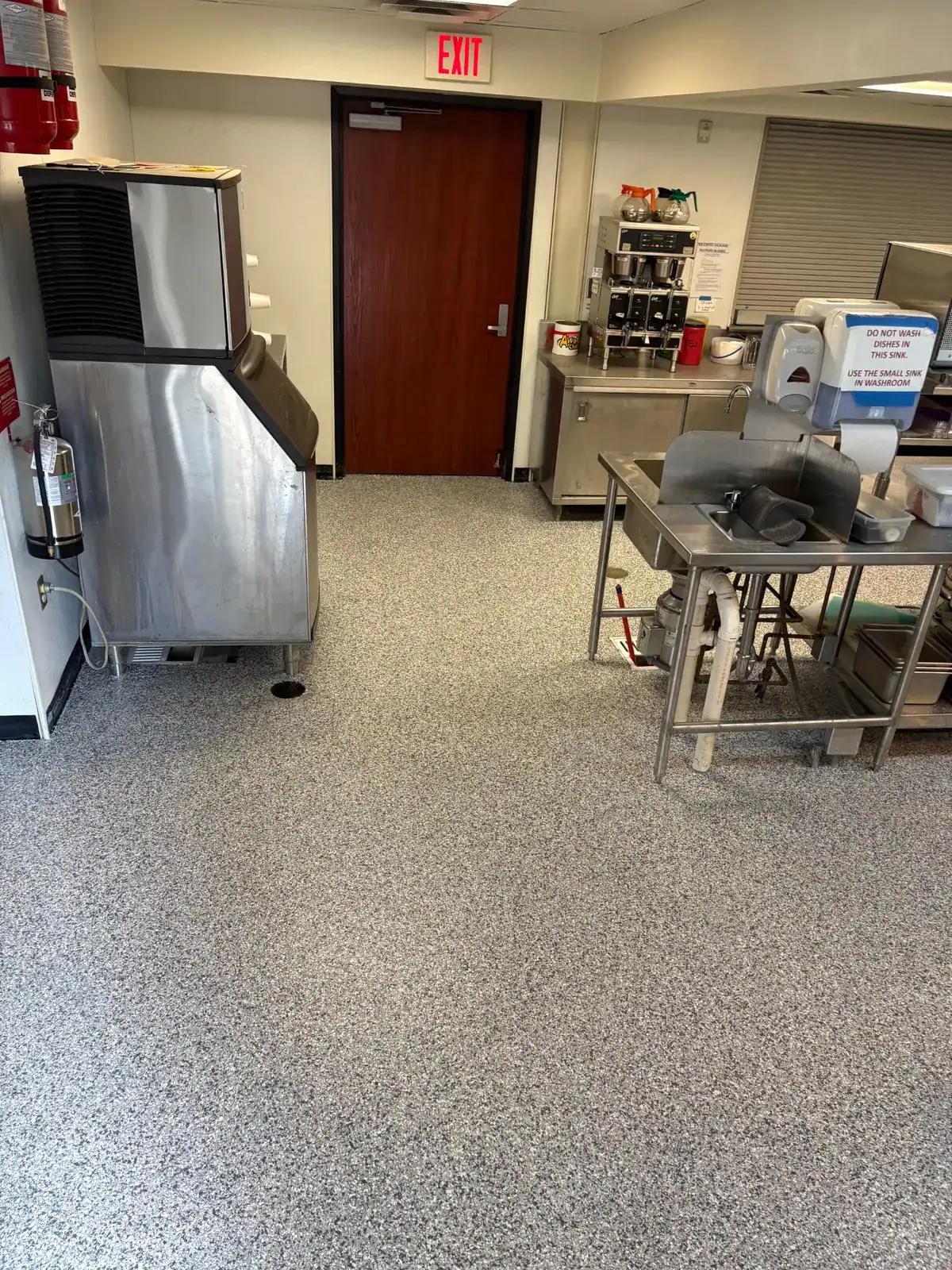 Completed commercial kitchen floor coating around equipment and a floor drain in Hawkins, Texas