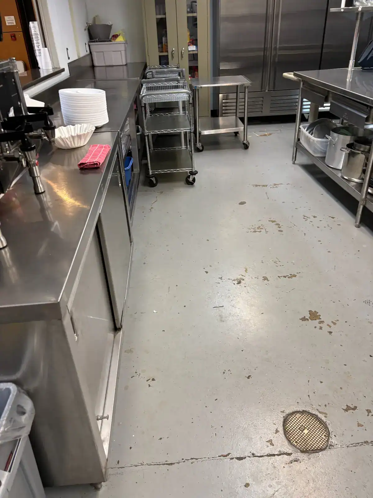 Worn gray commercial kitchen floor before coating at Holly Brook Baptist Church