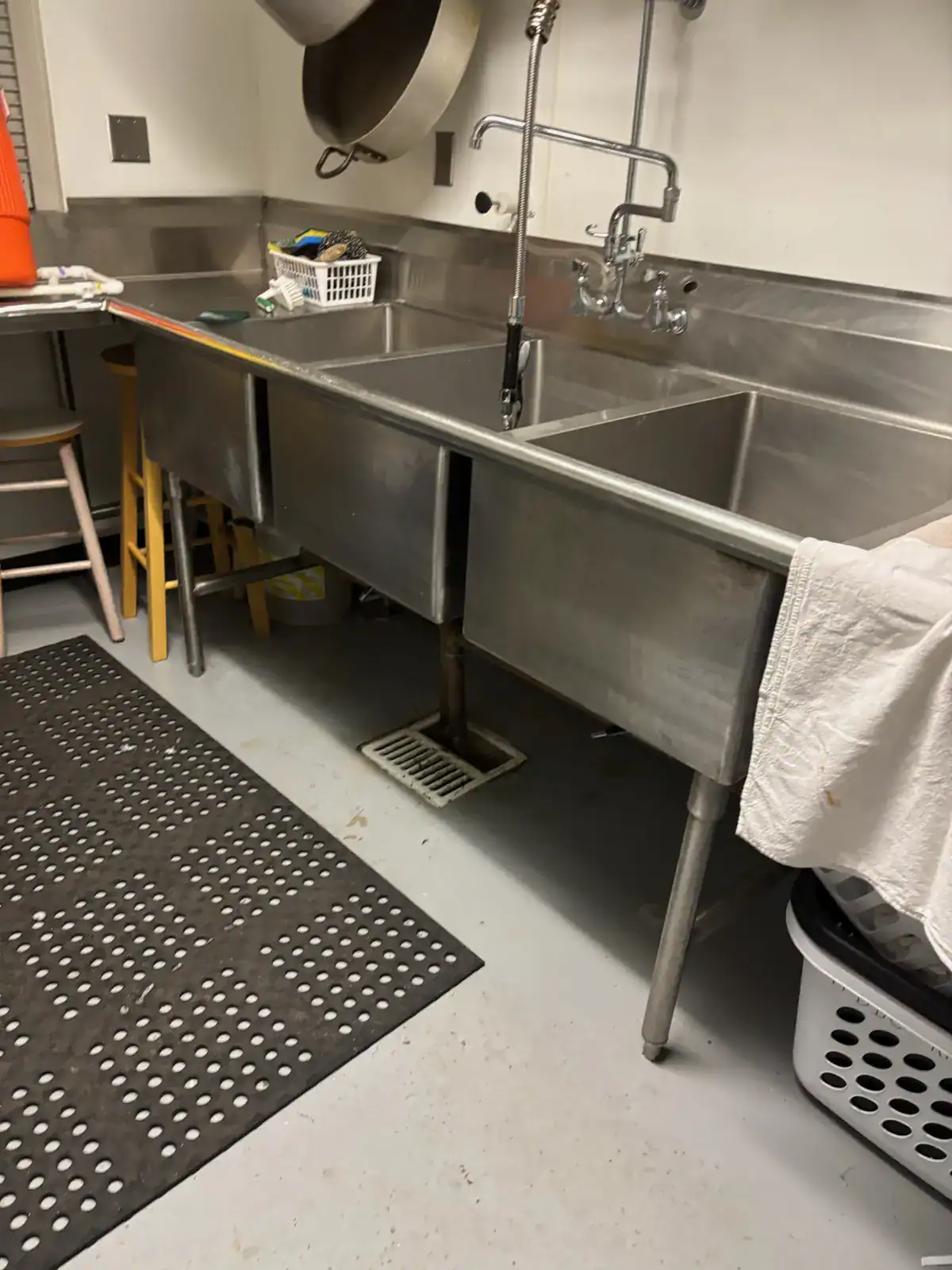 Commercial kitchen floor drain and worn gray coating before installation