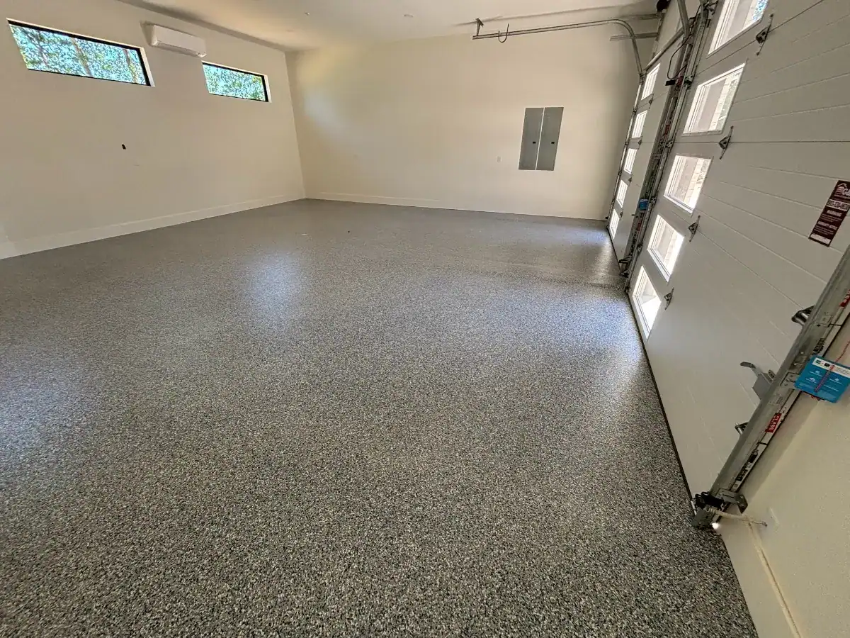 Finished custom full-broadcast flake floor near a garage entry in an East Texas lake house.