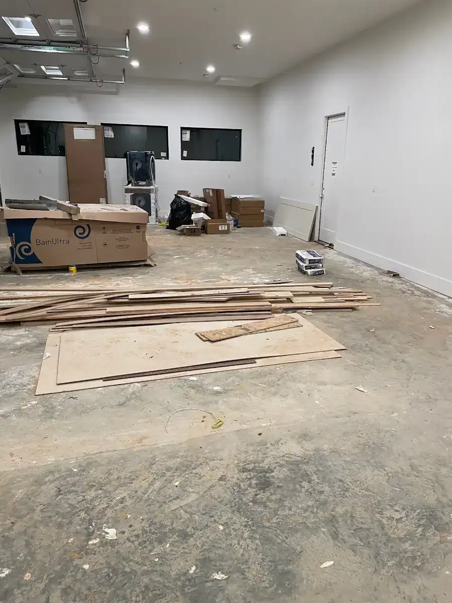 New-build East Texas garage with construction stains and materials on the unfinished concrete floor.