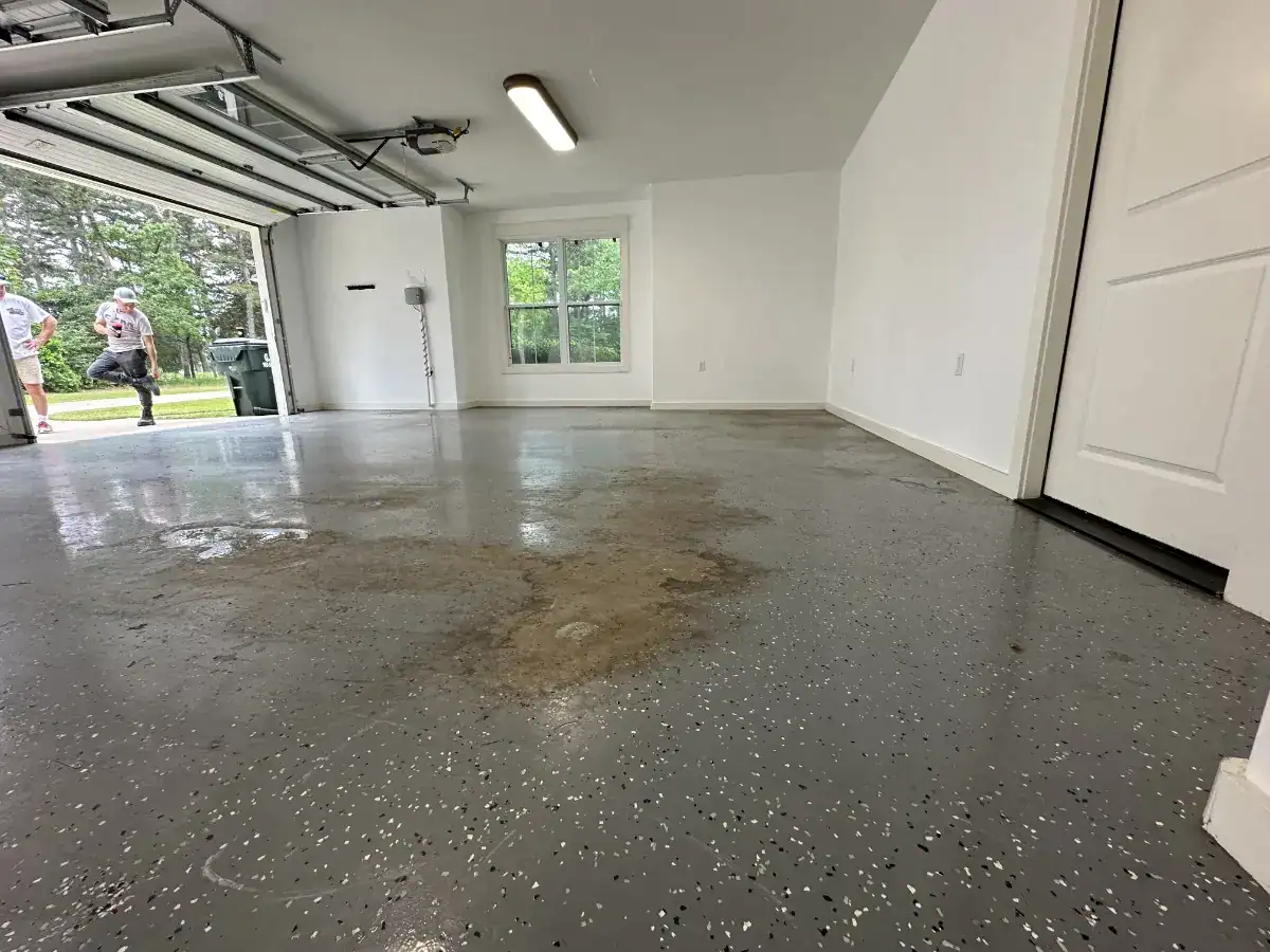 Failed gray DIY garage floor coating peeling from concrete in a Lindale, Texas garage