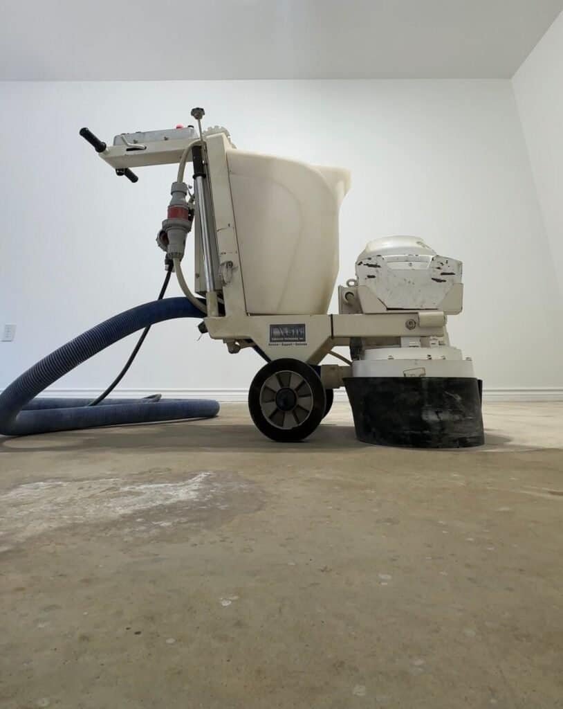 Industrial floor grinder preparing concrete surface for polyaspartic garage floor coating.